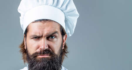 Portrait of a serious chef cook. Bearded chef, cooks or baker. Bearded male chefs isolated. Cook hat. Confident bearded male chef in white uniform. Serious cook in white uniform, chef hatの写真素材