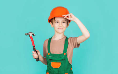 Little builder in helmet and hummer. Child dressed as a workman builder. little boy wearing helmet....