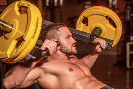 Muscular man workout with barbell at gym. Bodybuilder athletic man with six pack, perfect abs,...