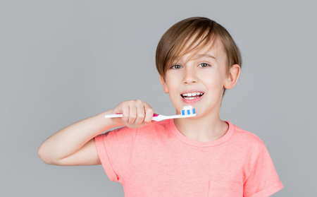 Joyful child shows toothbrushes. Little boy cleaning teeth. Dental hygiene. Happy little kid brushing her teeth. Kid boy brushing teeth. Boy toothbrush white toothpaste. Health care, dental hygieneの写真素材