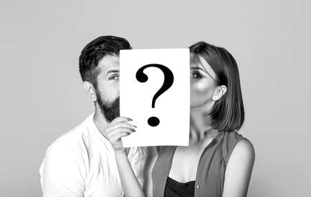Anonymous, man and woman question. Kiss couple, incognita. Problems and solutions. Couple in quarrel. Quarrel between people. Problem in couple, question mark. Couple holding paper question mark.の写真素材