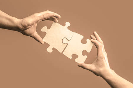 Hand connecting jigsaw puzzle. Business solutions, success and strategy concept. Man hands connecting couple puzzle piece. Business solutions, target, success, goals and strategy conceptsの写真素材