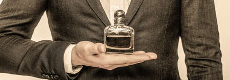 Perfume or cologne bottle and perfumery, cosmetics, scent cologne bottle, male holding cologne. Masculine perfume. Male holding up bottle of perfume. Man perfume, fragranceの写真素材