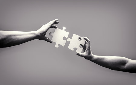 Hand connecting jigsaw puzzle. Business solutions, success and strategy concept. Man hands connecting couple puzzle piece. Business solutions, target, success, goals and strategy conceptsの写真素材