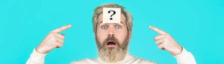 Beard man question mark in head, solution problems. Thinking man with question mark on blue background. Man with question mark on forehead looking up. Paper notes with question marksの写真素材