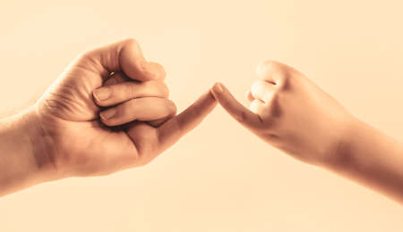 Friendship of generations. Father, daughter hand making promise friendship concept. Child hook little finger together. Little finger of the two hands hold together. Show friendship and forgivenessの写真素材