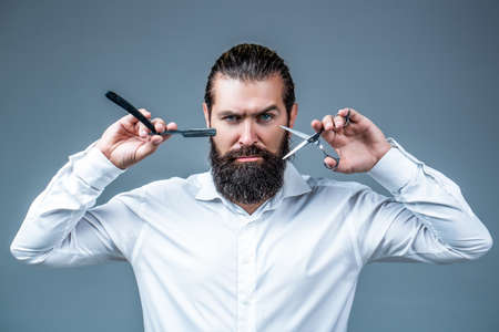 Barber scissors and straight razor, barber shop, suit. Vintage barber shop, shaving. Portrait bearded man. Mustache menの写真素材