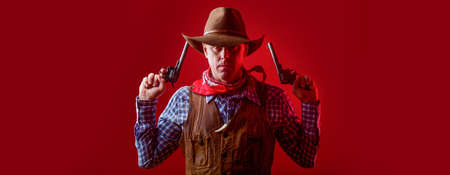 Western man with hat. Portrait of farmer or cowboy in hat. Man wearing cowboy hat, gun. Portrait of a cowboy. West, guns. Portrait of a cowboyの写真素材
