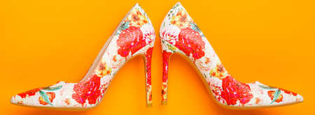 Stylish classic women leather shoe. Colored women shoes on yellow, orange background. Colorful leather shoes stiletto. Stylish female shoes in colors. Fashionable women shoesの写真素材