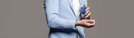 Masculine perfume, bearded man in a suit. Man perfume, fragrance. Male holding up bottle of perfume. Perfume or cologne bottle and perfumery, cosmetics, scent cologne bottle, male holding cologneの写真素材