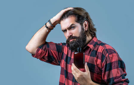 Man holds bottle of shampoo or shower gel. Shampoo conditioner for men. Expert care for demanding...
