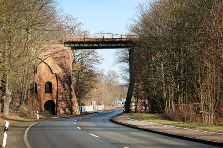 An old railway railway bridge over a roadの写真素材