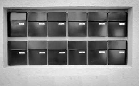 Mailboxes lined up in rows on a wallの写真素材