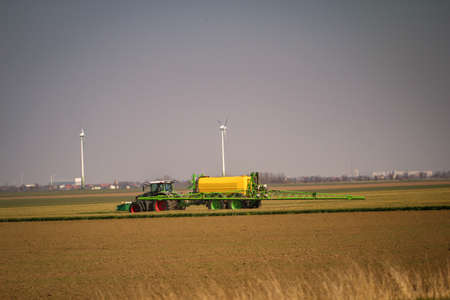 A farmer works the field with his tractor teamの写真素材