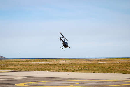 A helicopter with two main rotor blades at takeoff