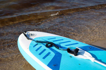 Details of a paddle board lying on the beach. Stand up paddle board.