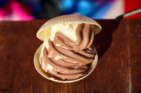 A soft ice cream with chocolate ice cream and vanilla between two waffle bowls.