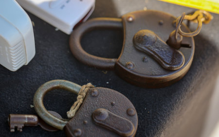 Two old padlocks lie on a table.の写真素材