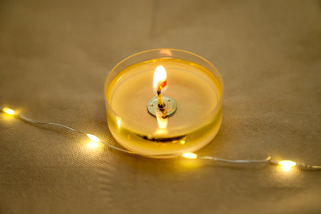 A burning tea light as a table decoration on a festively set table.