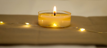 A burning tea light as a table decoration on a festively set table.の写真素材