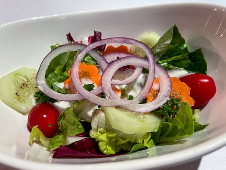 A salad plate full of a mixed salad and beautiful onion rings.の写真素材