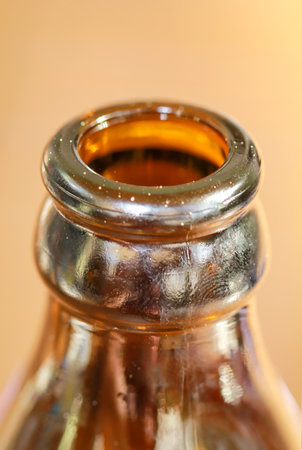 Close up of a brown beer bottle. Shallow depth of field. A close-up of a neck of a glass bottle for beverages.の写真素材