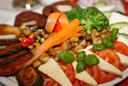 An Italian salad on a plate. Slices of tomato, basil and cheese.の写真素材