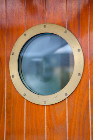 A porthole on a door on a ship.の写真素材