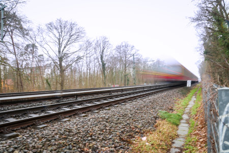 A train or a suburban train is traveling on a track. A long exposure, motion blur.