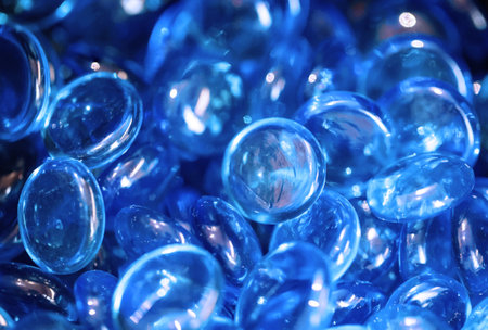 Colored glass balls in the shape of a ball. Abstract background. Close-up of many colored glass beads in a container.の写真素材