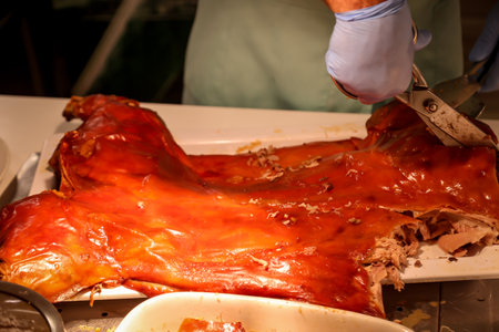 Honey glazed pork knuckle being prepared for roasting. A suckling pig is cut up and portioned.の写真素材