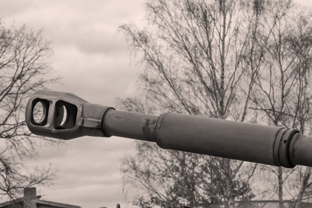 Close-up of the barrel of an old tank. Black and white photo. The gun barrel of a tank with muzzle brake.の写真素材