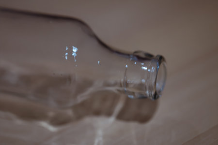 Empty glass bottle on a wooden background. Shallow depth of field. An empty glass drinks bottle.の写真素材
