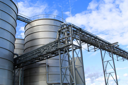 Industrial silos on blue sky background, closeup of photo