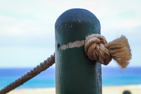 Closeup of a rope tied to a pole on the beach.の写真素材
