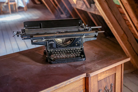 A typewriter on a table. Vintage typewriter on a wooden table in the attic of a country houseの写真素材