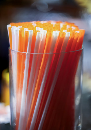 Drinking straws in a glass on the table. Selective focus.の写真素材