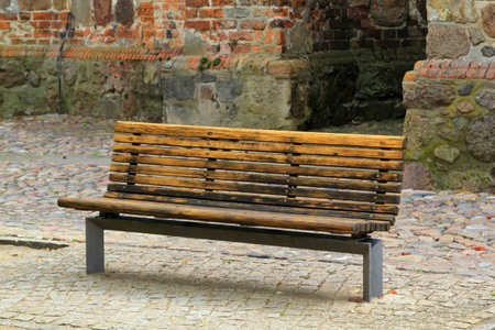 A park bench in front of an old building.の写真素材