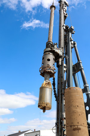 A caisson in use on a building site, for the construction of a foundation. Industrial crane with oil tank on blue sky background. Industrial backgroundの写真素材