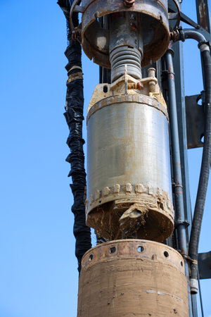 A caisson in use on a building site, for the construction of a foundation. Old oil pump on the background of the blue sky, close-upの写真素材
