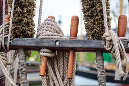 Details of a cutter, a ship, a sailing ship. Wooden pulley with ropes in the park, close-upの写真素材