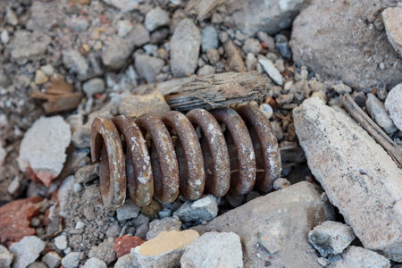 Lots of scrap on a demolition site. Rusty metal spring on a construction site. Selective focus.の写真素材