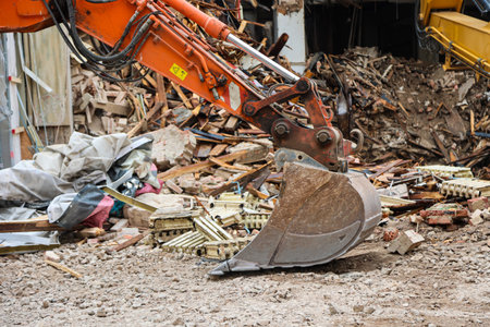 Detail of an excavator at a construction site. Demolition of a building site with excavator and other construction equipmentの写真素材