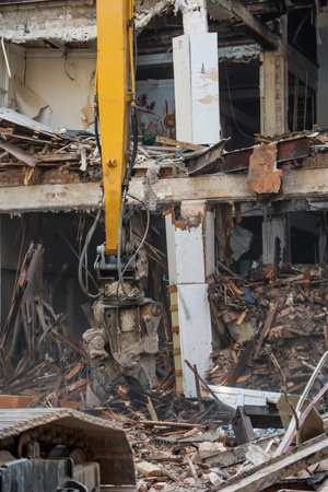An old department store that was dilapidated is being demolished. Demolition of an old building with crane, closeup of photoの写真素材