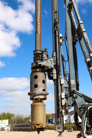 A drill rig for caissons at a construction site. Drilling rig in a field with blue sky and white clouds.の写真素材