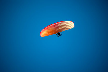 A motor-powered paraglider in the sky.