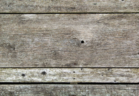 A texture of wood exposed to the weather. Old wooden planks with knots and nail holes as a background textureの写真素材