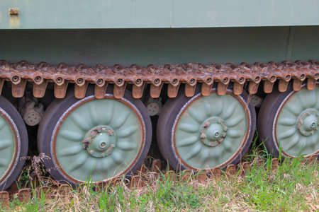 Close-up of a tank with green wheels on the grass. Detail of an old tank.