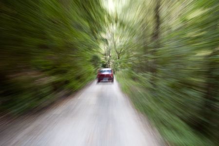 Zoom effect of car traveling through the forest on a dirt road の写真素材