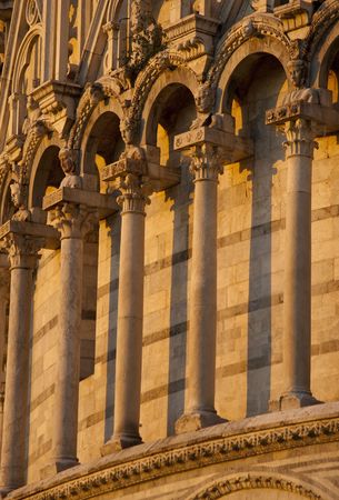 romanesque columns and arches at cathedral in Pisa Tuscany Italy in late afternoon golden lightの写真素材